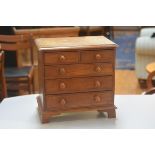 A 19thc oak miniature apprentice style chest, the rectangular top with moulded edge above two short