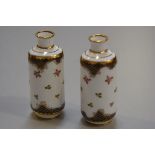 A pair of Crown Staffordshire miniature cylinder vases decorated with roses and gilt blue reserves (