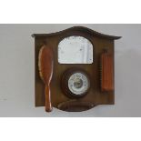 A 1920s/30s walnut hall mirror with aneroid barometer, mounted with three various clothes brushes (h