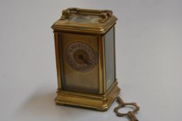 An Edwardian French four glass brass carriage clock with silvered dial and arabic numerals, complete