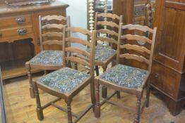 A set of four Ercol ash ladderback dining chairs with slip in seats, raised on turned baluster suppo