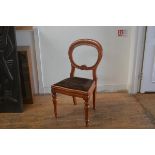 A Victorian stained beech balloon back desk chair with inset seat, raised on turned tapered supports