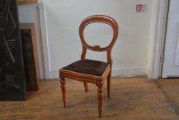 A Victorian stained beech balloon back desk chair with inset seat, raised on turned tapered supports