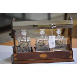 An Edwardian mahogany inlaid three division tantallus complete with three replacement bottles with w