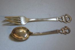 A Norwegian child's Christening fork and spoon set, stamped 830, with terminals cast as mountain goa