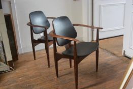 A stylish pair of Swedish teak bentwood open arm carver chairs with black vinyl upholstered panel ba