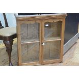 A 19thc pine twin glazed door cabinet with moulded cornice, fitted two shelves (h.78cm l.72cm x d.20