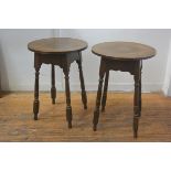 A pair of oak turned wood occasional tables with circular tops and shaped aprons on splay tapered ba
