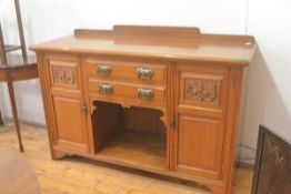 An Arts & Crafts oak ledgeback sideboard fitted two centre drawers above an open well, flanked by ca