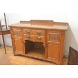 An Arts & Crafts oak ledgeback sideboard fitted two centre drawers above an open well, flanked by ca