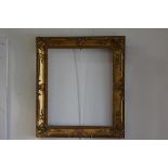 A 19thc rococco style gilt composition frame (exterior: 83cm x 73cm. Interior 62cm x 52cm) (losses)