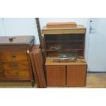 A mid century teak three part modular shelving system including a bookcase top with twin sliding gla