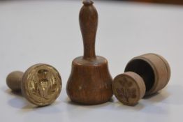 Two 19thc treen butter pats with thistle and strawberry leaf design and a miniature treen mallet (h.