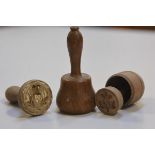 Two 19thc treen butter pats with thistle and strawberry leaf design and a miniature treen mallet (h.