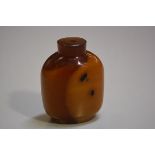 A Chinese Peking amber glass snuff bottle with encased dark shadows (h.6.5cm), missing stopper, £20-