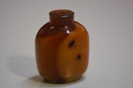 A Chinese Peking amber glass snuff bottle with encased dark shadows (h.6.5cm), missing stopper, £20-