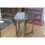 An oak oval drop leaf gateleg tea table, the top with moulded edge, raised on barley twist supports