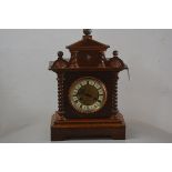 A Victorian oak mantle clock with pedimented top, above a circular enamelled dial, with roman numera