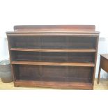 A mahogany upright open ledgeback bookcase, fitted three adjustable shelves, raised on bracket feet