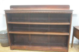 A mahogany upright open ledgeback bookcase, fitted three adjustable shelves, raised on bracket feet