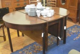 A George III mahogany double D end and centre twin drop leaf extending dining table, the top with mo