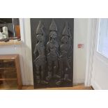 An African hardwood two section relief carved panel depicting three female figures carrying water go