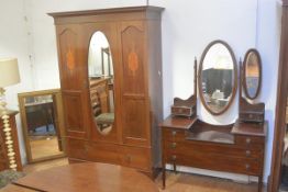 An Edwardian mahogany two piece bedroom suite comprising wardrobe, with inlaid cornice and oval cent