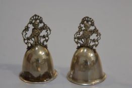 A pair of Kraftalpacca white metal pierced figure bells with engraved intials A and M (missing clapp