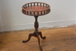 A reproduction mahogany galleried occasional table with inset circular skiver, on turned vase column