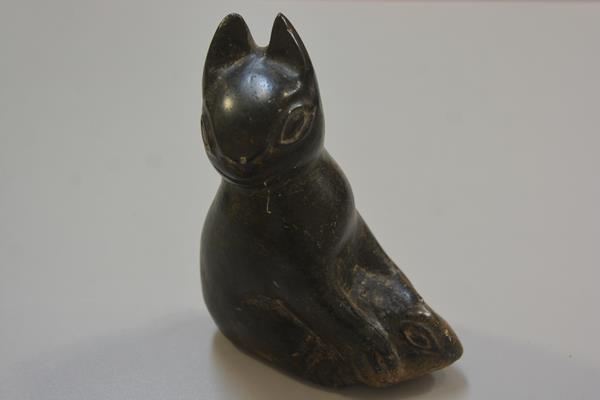 An Inuit soapstone carving of a cat holding a fish, unsigned (h.17cm x l. 13cm)