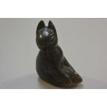 An Inuit soapstone carving of a cat holding a fish, unsigned (h.17cm x l. 13cm)