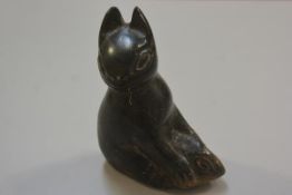 An Inuit soapstone carving of a cat holding a fish, unsigned (h.17cm x l. 13cm)