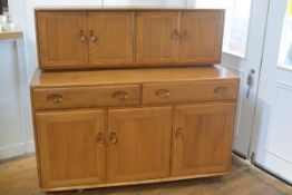 In pristine condition: an Ercol light elm sideboard, the top fitted two pairs of moulded panel doors