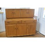 In pristine condition: an Ercol light elm sideboard, the top fitted two pairs of moulded panel doors