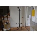 A mid century tubular steel industrial hat and coat stand with six scrolling branches to top and S