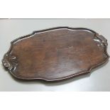 A nice Edwardian oval mahogany scalloped bordered tea tray with fan shell scroll carved handles to