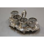 An Edwardian Sheffield plated four section pierced cup holder serving dish with C scroll border