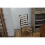 An Edwardian Arts & Crafts child's ladder back open armchair with rush seat (h. 85cm x w.49cm x d.