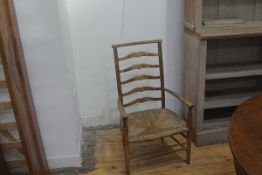 An Edwardian Arts & Crafts child's ladder back open armchair with rush seat (h. 85cm x w.49cm x d.