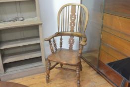 A 19thc elm spindle back open armchair with scroll arms and turned spindles, with saddle shaped