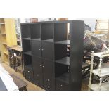 An Ikea modular black ash storage unit fitted four open sections to top with an arrangement of
