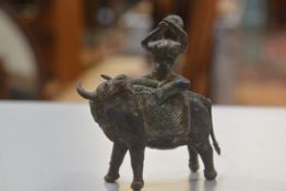A bronze cast Indian musician figure riding on a sacred cow (h.17cm x l.17cm)