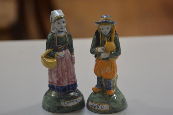 A pair of Quimper figures, a Man with Bagpipes and a Woman with Shopping Basket, decorated with