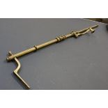 A 19thc brass portiere complete with brass wall fixing and twelve original curtain rings, with