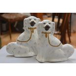 A pair of 19thc china chimney spaniels decorated with polychrome enamels (h.29cm x l.26cm)