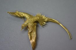 An 18ct gold textured bird of paradise brooch with inset diamond eye, stamped 18k. (l. 8.5cm) (10.