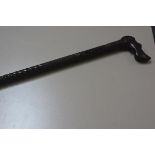 An African style ebony carved walking cane with hound's head handle and diamond cut and fluted