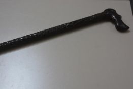 An African style ebony carved walking cane with hound's head handle and diamond cut and fluted