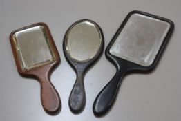 An ebony square shaped 19thc hand mirror with bevelled plate, a stained ebonised oval hand mirror