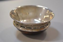 An ash treen bowl in the Arts and Crafts style with Chester silver hammered lining and rim with bead